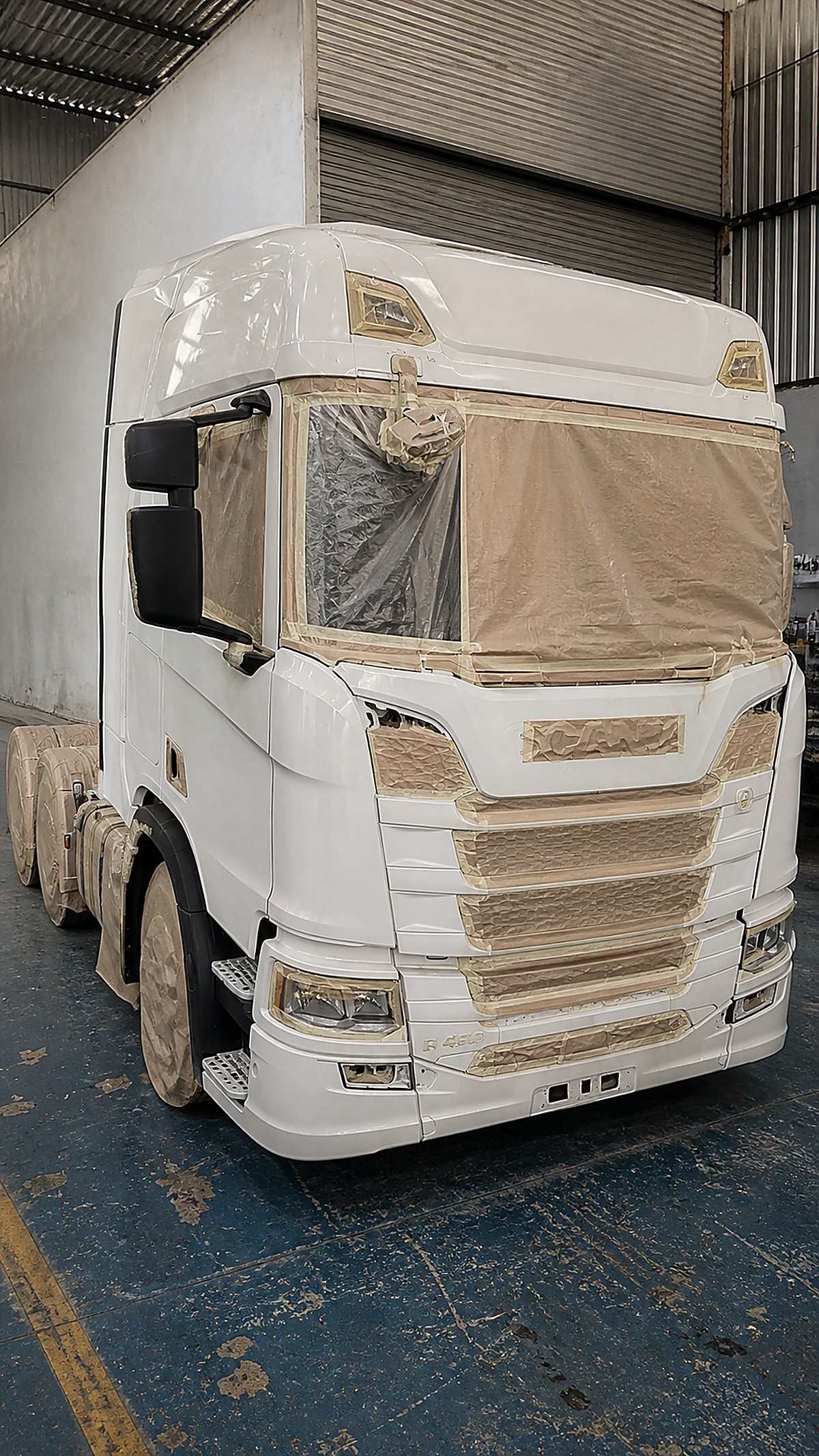 Cabine mascarada antes da pintura: vidros, borrachas e faróis protegidos